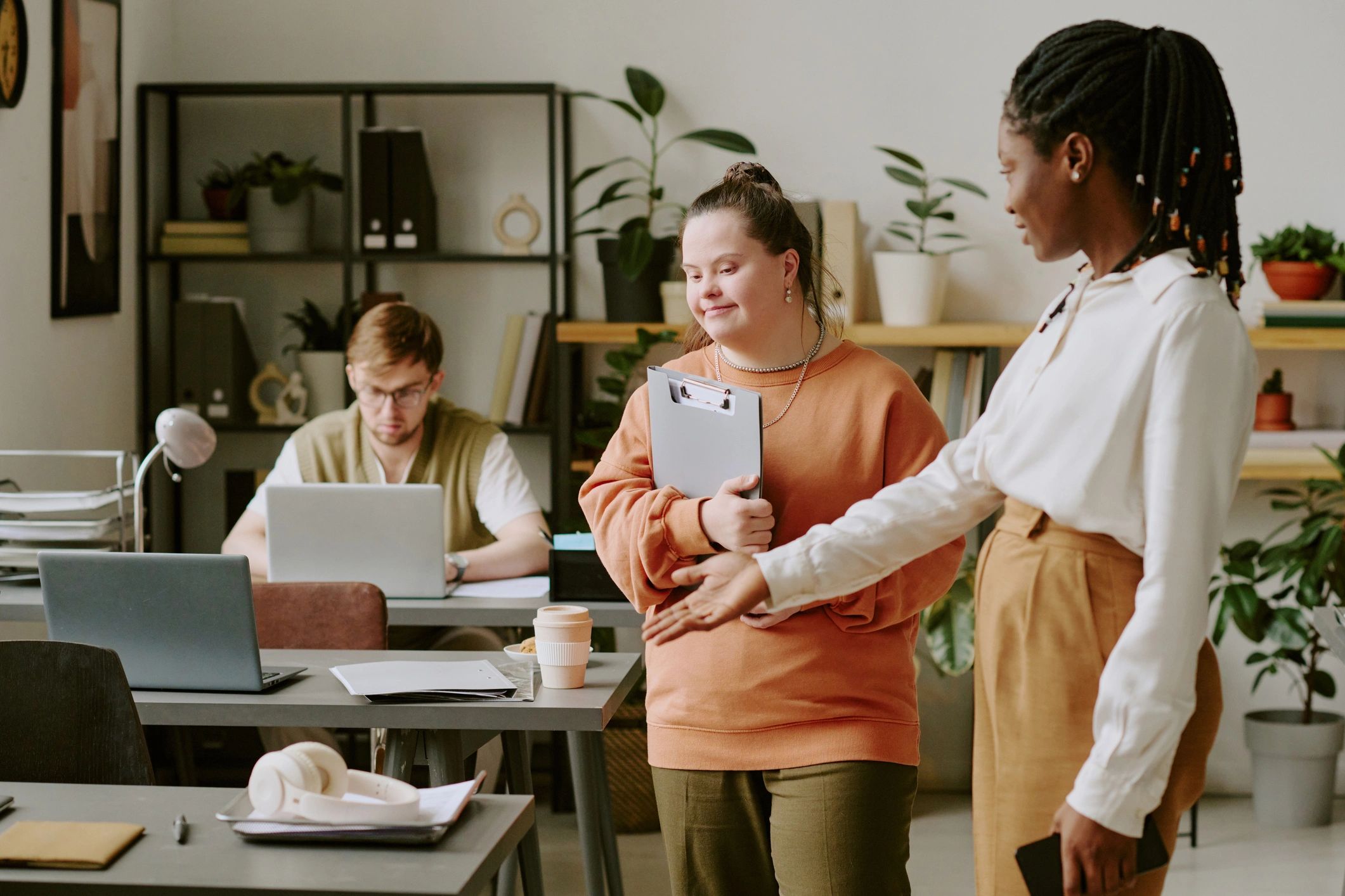 Young professional with Down syndrome being welcomed at a workplace desk